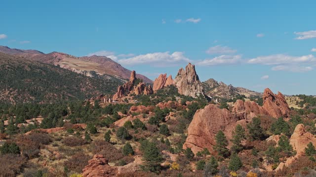 Drone parallax around sheets of large red sandstone sticking up from ground in Garden of the Gods Colorado