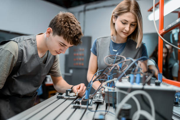 istock Male Student Checking Motor Function Initiated By PLC Unit Operated By Female Friend 1857850085