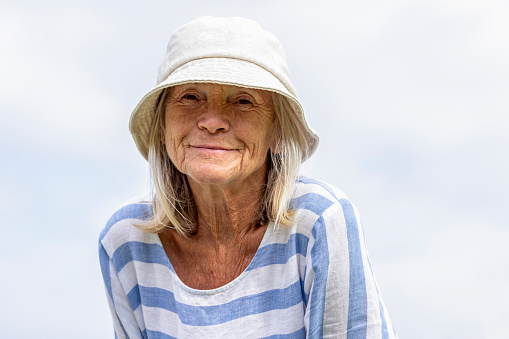 Portrait of happy senior woman with summer hat, background with copy space, full frame horizontal composition