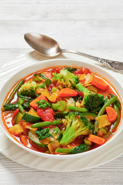 istock vegetable soup with green beans, broccoli, carrot, celery, spinach, cabbage, zucchini, tomatoes in white bowl 1857900728