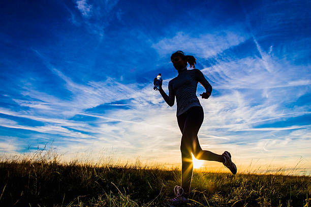 istock Young woman jogging in a field 185791232