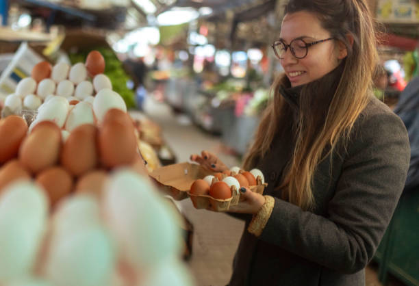 istock A smiling woman chooses eggs and arranges them in an egg carton 1857935665