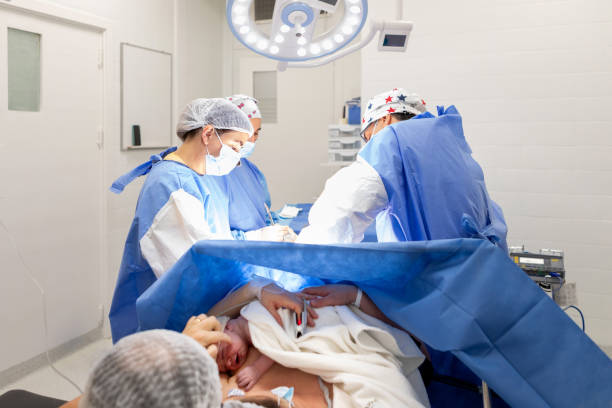 lekarze wykonujący cięcie cesarskie na sali operacyjnej - cesarka zdjęcia i obrazy z banku zdjęć