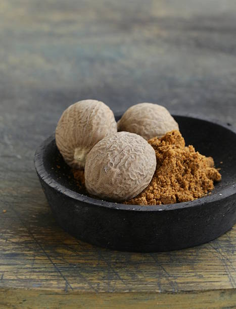 istock nutmeg whole and grated on a wooden table 185794441