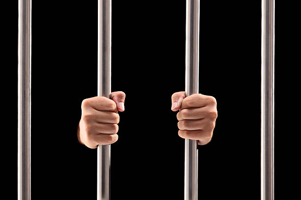 istock Male hands holding prison bars 185794696