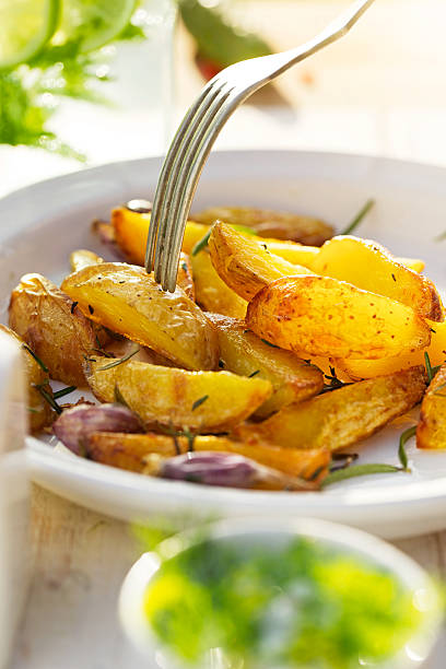 aglio e rosmarino, patate arrosto con zeppa - potatoes au gratin foto e immagini stock