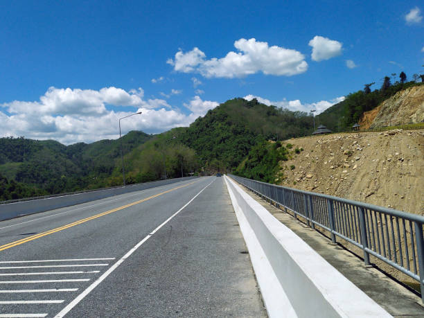 istock The road on the mountain with blue sky and white clouds background. 1857976306