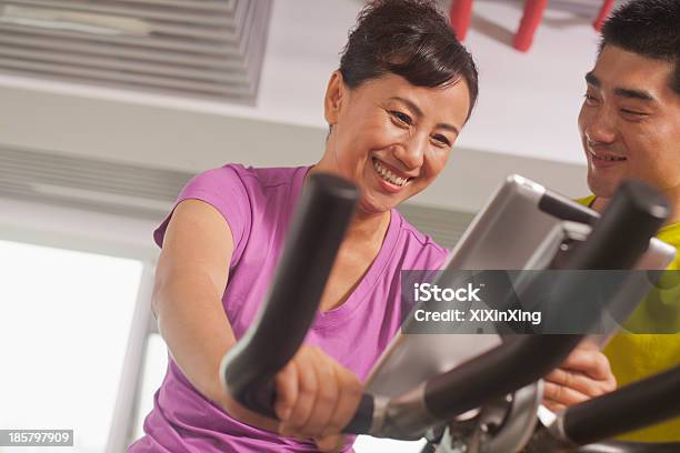 Mujer Ejercicio De Ejercicio En Bicicleta Con Su Entrenador Personal Foto de stock y más banco de imágenes de Agarrar