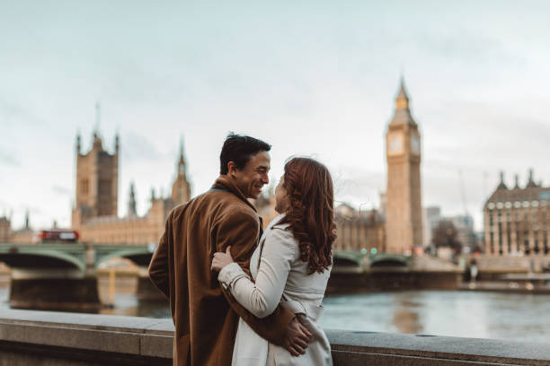 happy and young tourist couple enjoying a romantic getaway in iconic streets of london city, england, united kingdom - romantic getaway stock-fotos und bilder