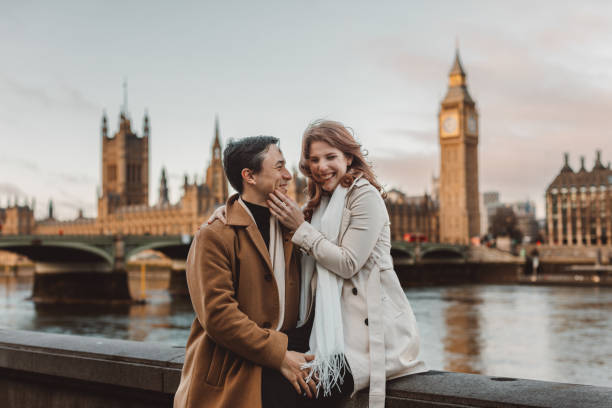 happy and young tourist couple enjoying a romantic getaway in iconic streets of london city, england, united kingdom - romantic getaway stock-fotos und bilder