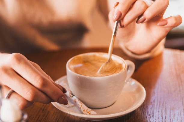istock A girl drinks latte coffee at a wooden table. 1858018167
