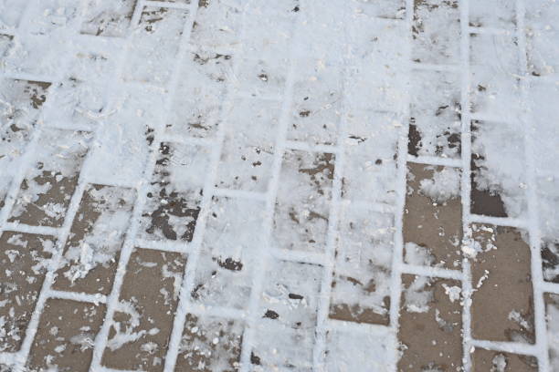 istock snow-covered asphalt, snow-covered road surface asphalt tile covered with thin ice crust, icy ice tile, concrete tile texture on asphalt 1858053021