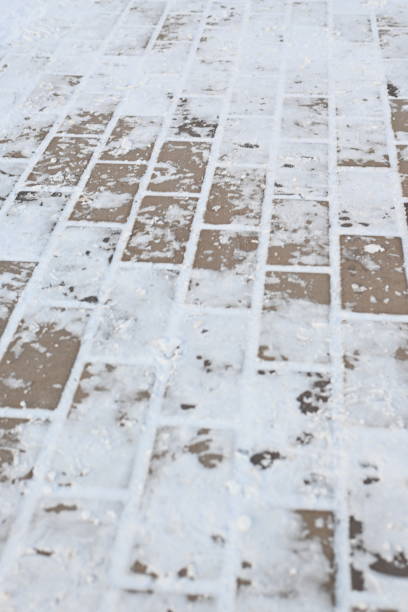 istock snow-covered asphalt, snow-covered road surface asphalt tile covered with thin ice crust, icy ice tile, concrete tile texture on asphalt 1858053032