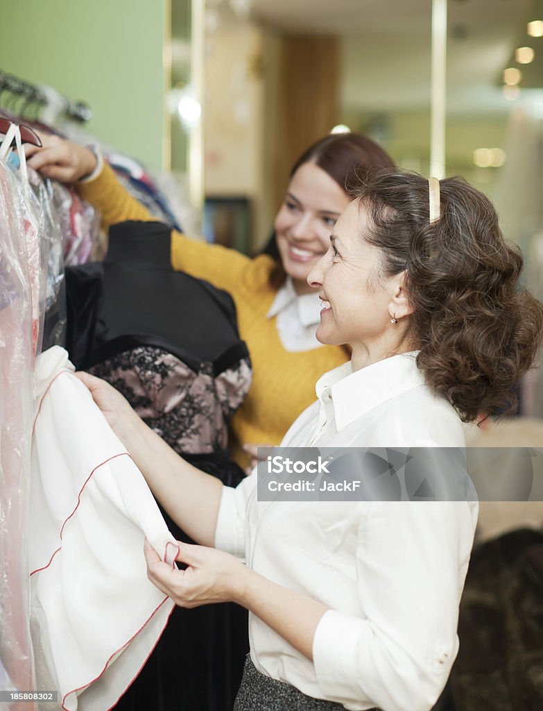 Feliz mujer elige vestido de noche - Foto de stock de 20 a 29 años libre de derechos