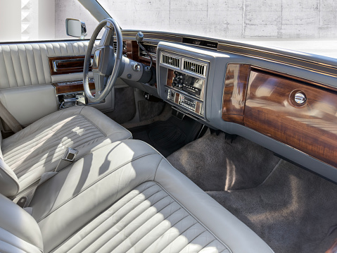 Interior detail from a classic status car with steering wheel, dashboard, and glove compartment