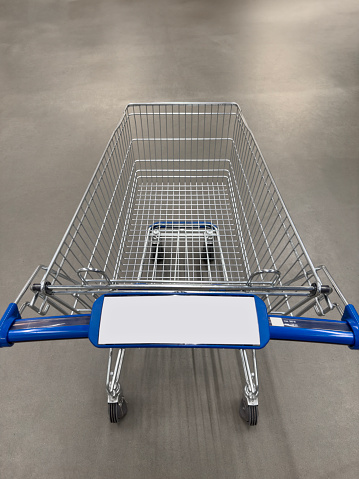 Looking down on an empty shopping cart on concrete floor