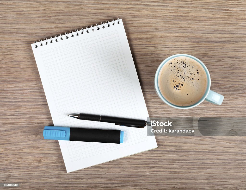 Blank notepad and coffee cup Blank notepad and coffee cup on office wooden table Above Stock Photo