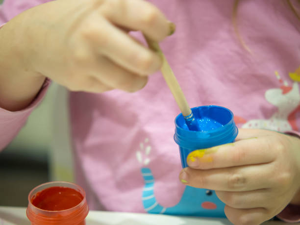 istock little girl draws with paints. 1858197280