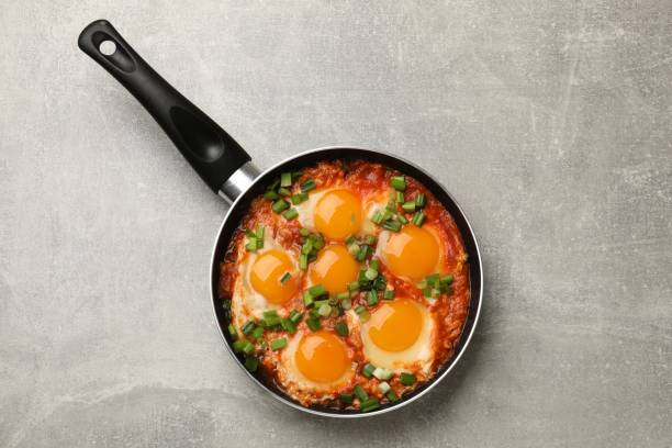 istock Delicious Shakshuka in frying pan on light grey table, top view 1858200665