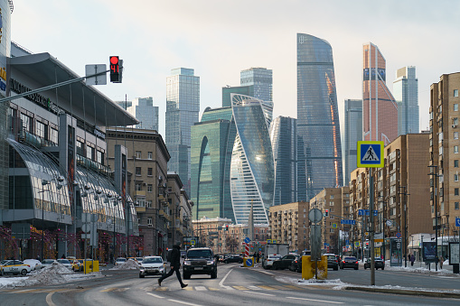 Moscow, Russia - February 5, 2021: Old houses are combined with modern buildings. MIBC (Moscow International Business Center). People crossing avenue. Bolshaya Dorogomilovskaya
