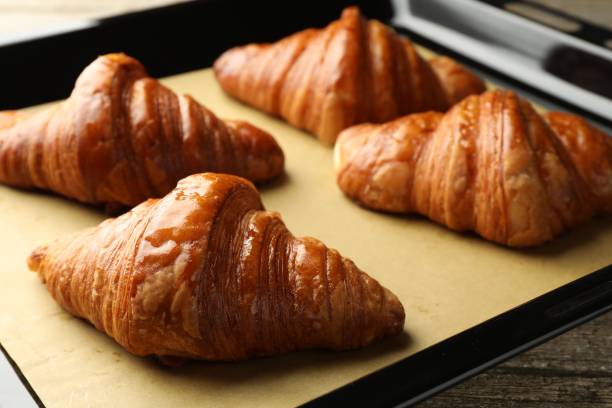istock Baking dish with delicious fresh croissants on table, closeup 1858216514