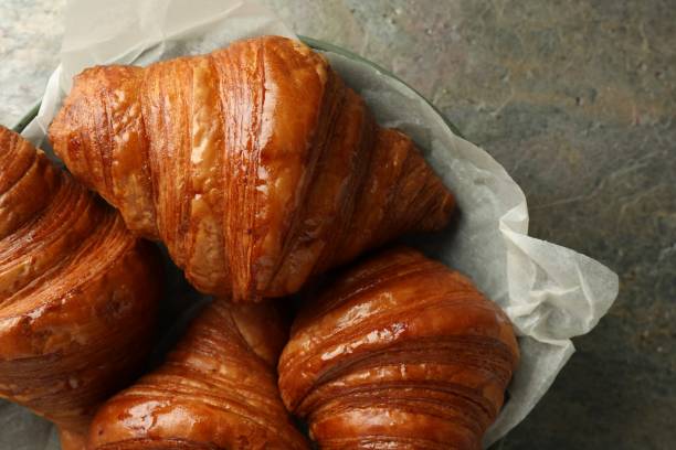 istock Delicious fresh croissants on grey textured table, top view 1858216539