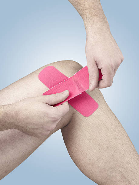 physiotherapie für knie schmerzen, schmerzen und verspannungen - human knee physical injury bandage muscular build stock-fotos und bilder