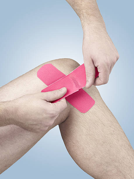 fisioterapia del ginocchio dolore, indolenzimento e iperteso - human knee physical injury bandage muscular build foto e immagini stock