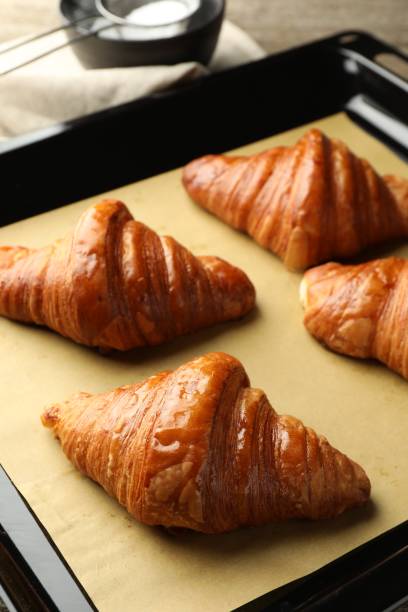 istock Baking dish with delicious fresh croissants on table, closeup 1858219476