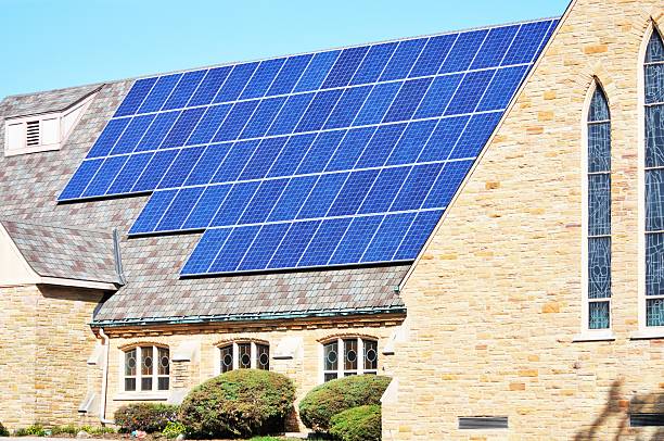 Solar Church Solar panels on roof of church building. (For Thine is the Power) solar panels on the roof of building in a city stock pictures, royalty-free photos & images