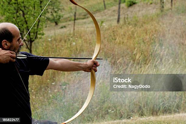Man Shooting With Bow — стоковые фотографии и другие картинки Archery - Archery, Взрослый, Вооружение