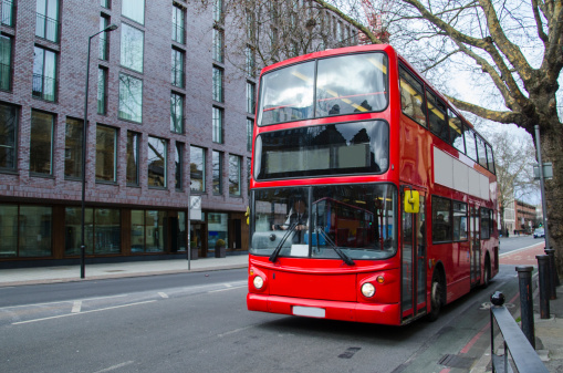 A two-stories londoner bus, parked in a street of the British capital.
