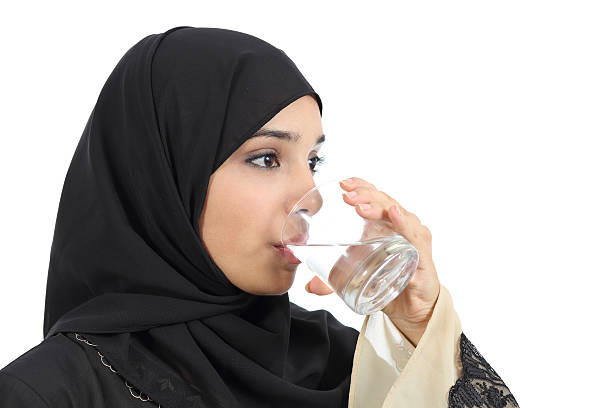 istock Arab woman drinking water from a glass 185823673