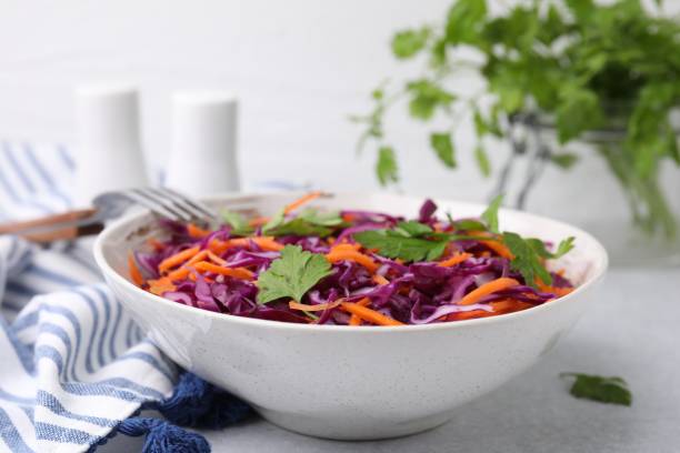 istock Tasty salad with red cabbage in bowl on light grey table, closeup 1858257905