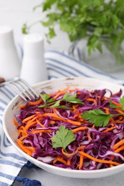 istock Tasty salad with red cabbage in bowl on light grey table, closeup 1858257959