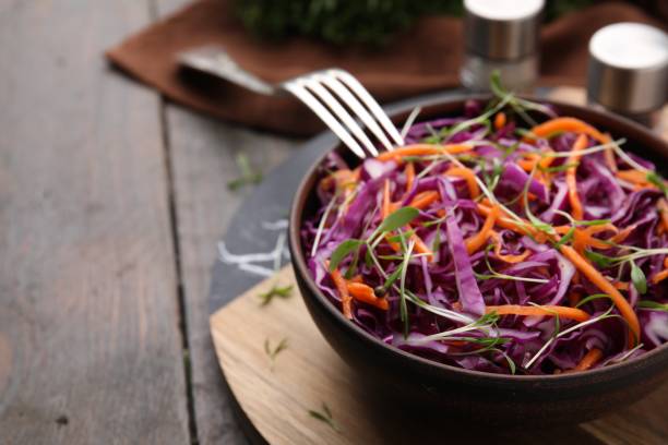 istock Tasty salad with red cabbage on wooden table, closeup. Space for text 1858258928