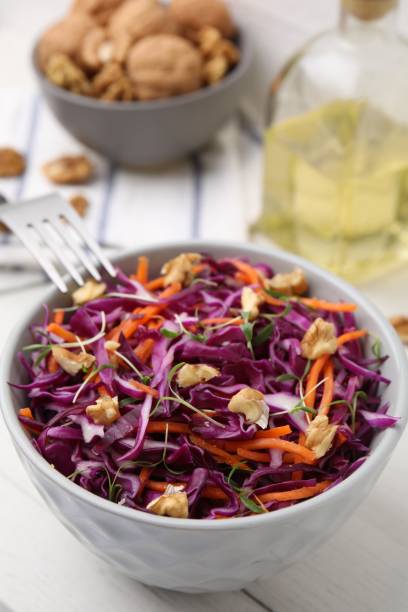 istock Tasty salad with red cabbage and walnuts at white table, closeup 1858258936