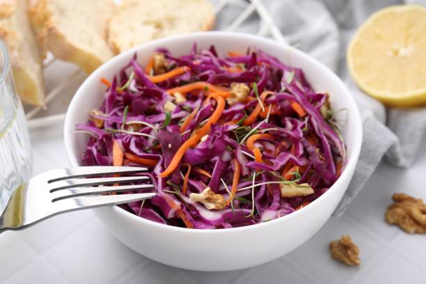 istock Tasty salad with red cabbage and walnuts on white tiled table, closeup 1858261003