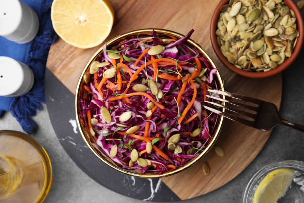 istock Eating tasty salad with red cabbage and pumpkin seeds on table, flat lay 1858262038