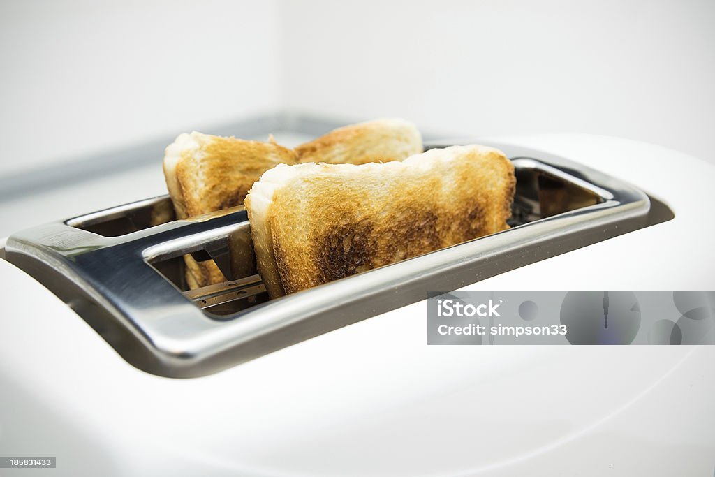 Tostapane con fette di pane su sfondo bianco - Foto stock royalty-free di Affamato