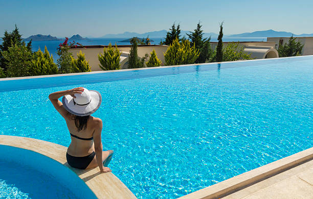istock Young woman sits by pool 185832429