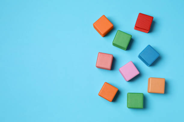 istock Blank colorful cubes on light blue background, flat lay. Space for text 1858337476