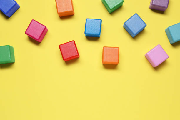 istock Blank colorful cubes on yellow background, flat lay. Space for text 1858337984