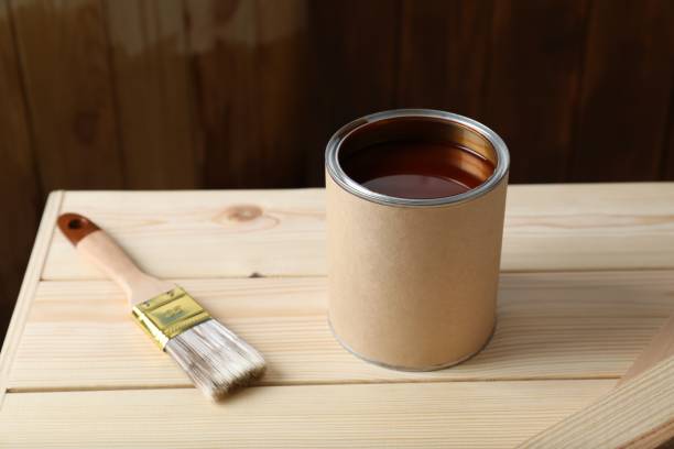 istock Can and brush with wood stain on wooden surface 1858339536