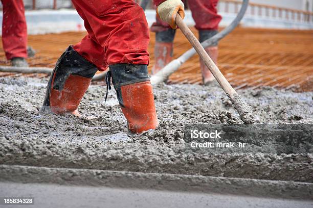 Los Trabajadores En Rojo Botas Con Rastrillo Ajustarse El Cemento Foto de stock y más banco de imágenes de Acabar