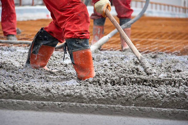 istock Workers in red boots with rake leveled the concrete 185834328