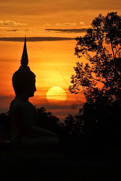 istock sunset in front of a buddhist sculpture 185835280