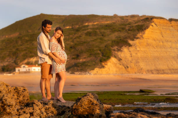 pregnant couple at the beach - human pregnancy couple prenatal care heterosexual couple imagens e fotografias de stock