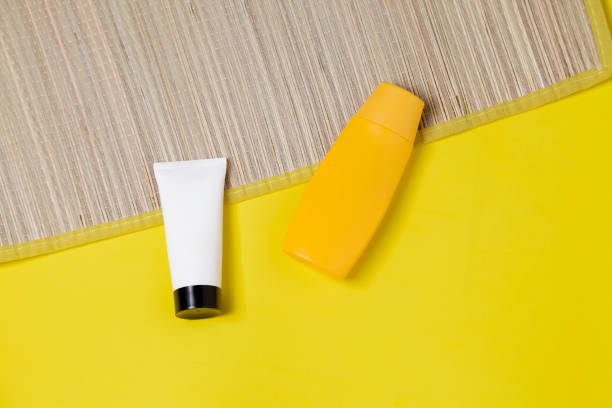 istock Straw mat on yellow background with bottles of sunscreen 1858392889