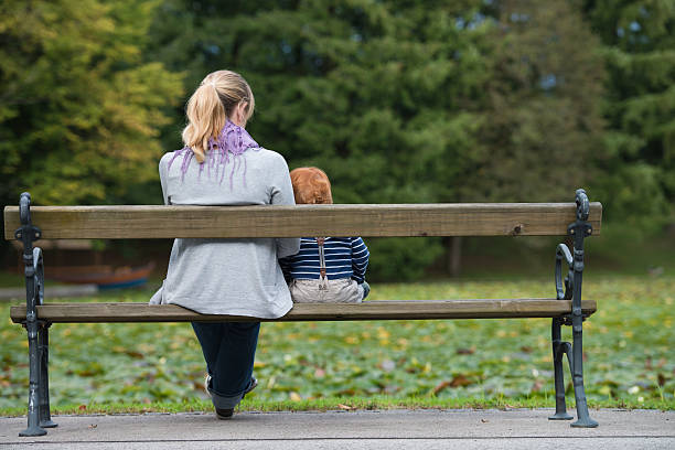 istock Mother and son sitting on park bench. 185840913